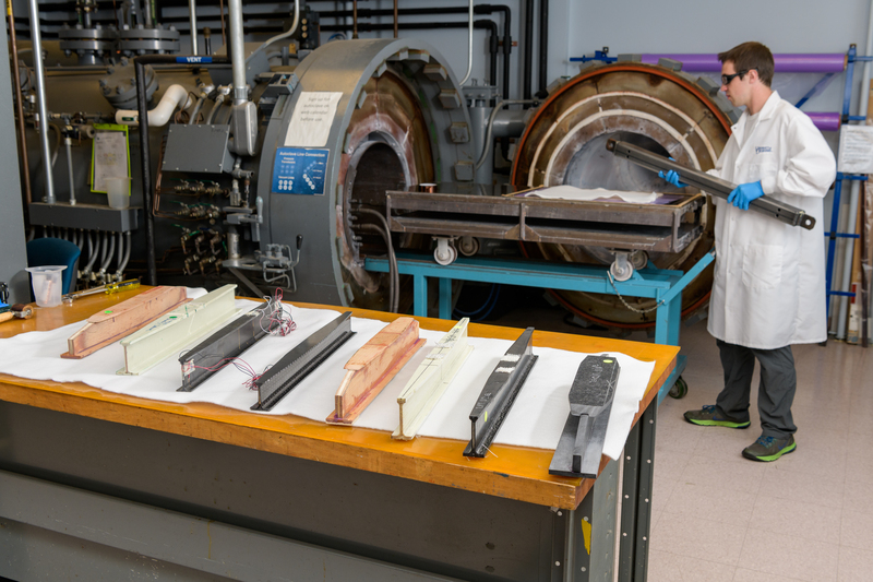CCM researcher in white lab coat prepares to insert a prototype into an autoclave.