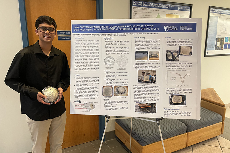 A high school intern presents his research poster at the end of the summer.
